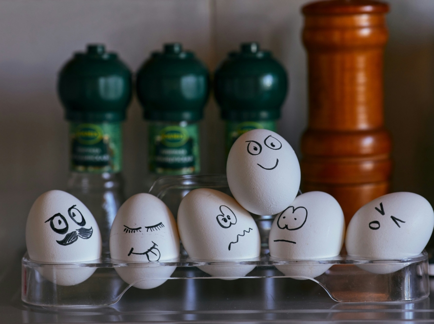 Painted faces on eggs on a glass rack